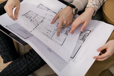 Two investors examining architectural blueprints for a build-to-rent property.