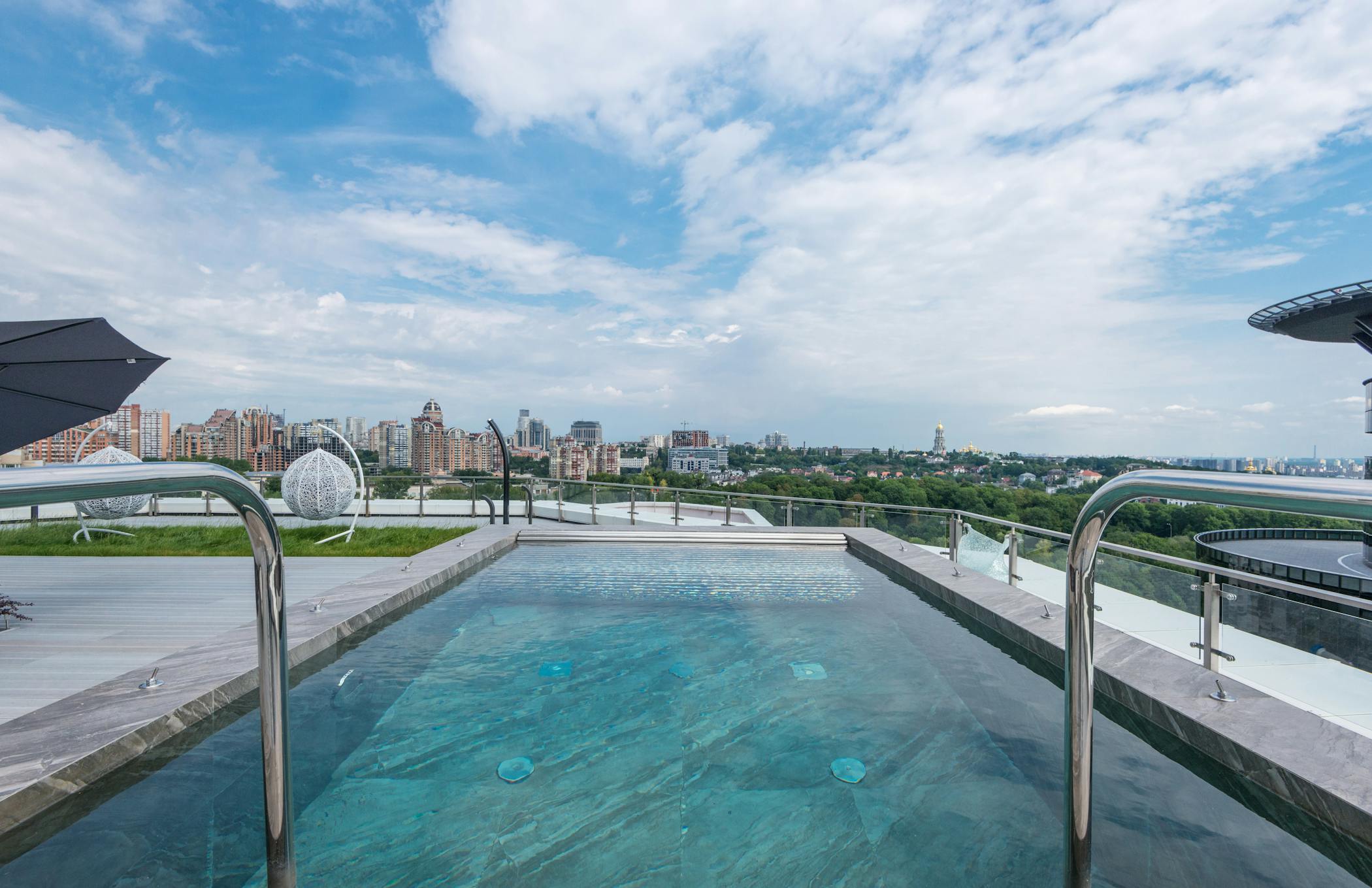 Luxurious rental rooftop pool with cityscape backdrop, perfect blend of nature and architecture.