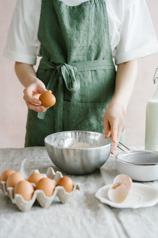 Close-up of a person preparing a baking mixture with fresh ingredients like eggs symbolizing a renter having chickens with their landlord's approval.