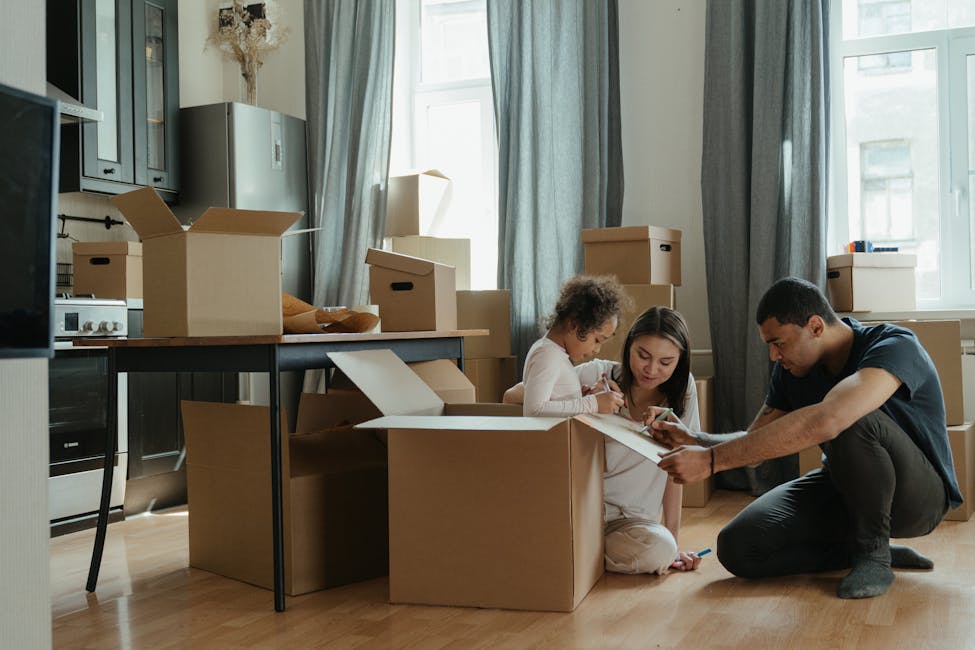 A family unpacks moving boxes in their new rental home as tenants with property management company.