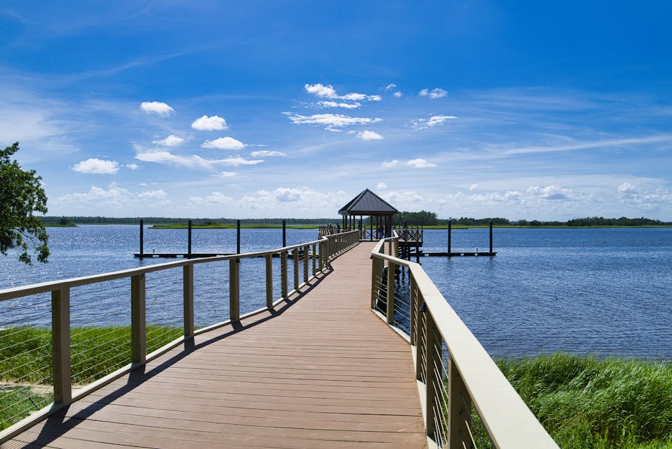 A serene pier over calm lake waters under a clear blue sky in Wilmington, NC showcasing the 6th ranked spot for best places for renters in 2025.