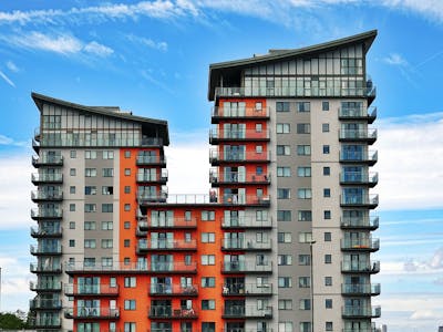 Modern high-rise apartment buildings with unique architecture under a vibrant blue sky showcasing the decline as vacancy rates hit new highs.