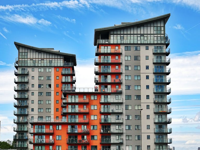 Modern high-rise apartment buildings with unique architecture under a vibrant blue sky showcasing the decline as vacancy rates hit new highs.
