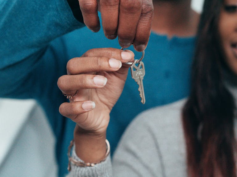 A couple holding a key, symbolizing a new home rental showcasing the pricing scheme with Greystar.