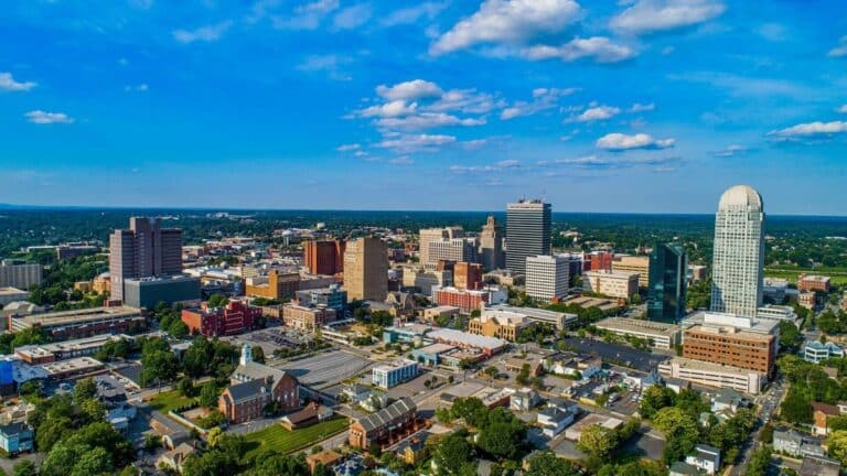 An aerial or elevated view of the Winston Salem's city skyline and urban architecture showcasing three major developments.