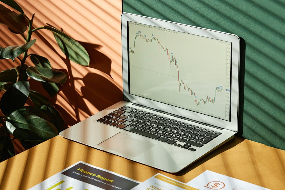 Laptop displaying a financial graph with reports, in a sunlit workspace showcasing the warm-weather cities who are leading rental market declines.