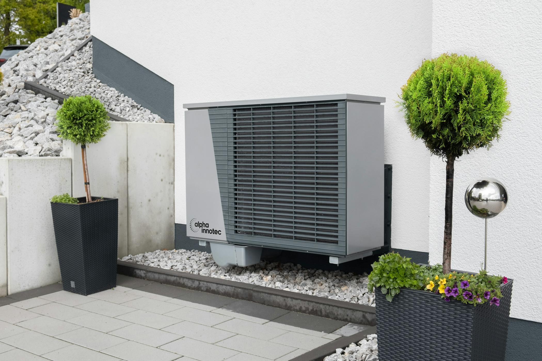 Modern air conditioning unit with flower pots and sleek decor outdoors showcasing owner mistakes that are costing them money with HVACs.