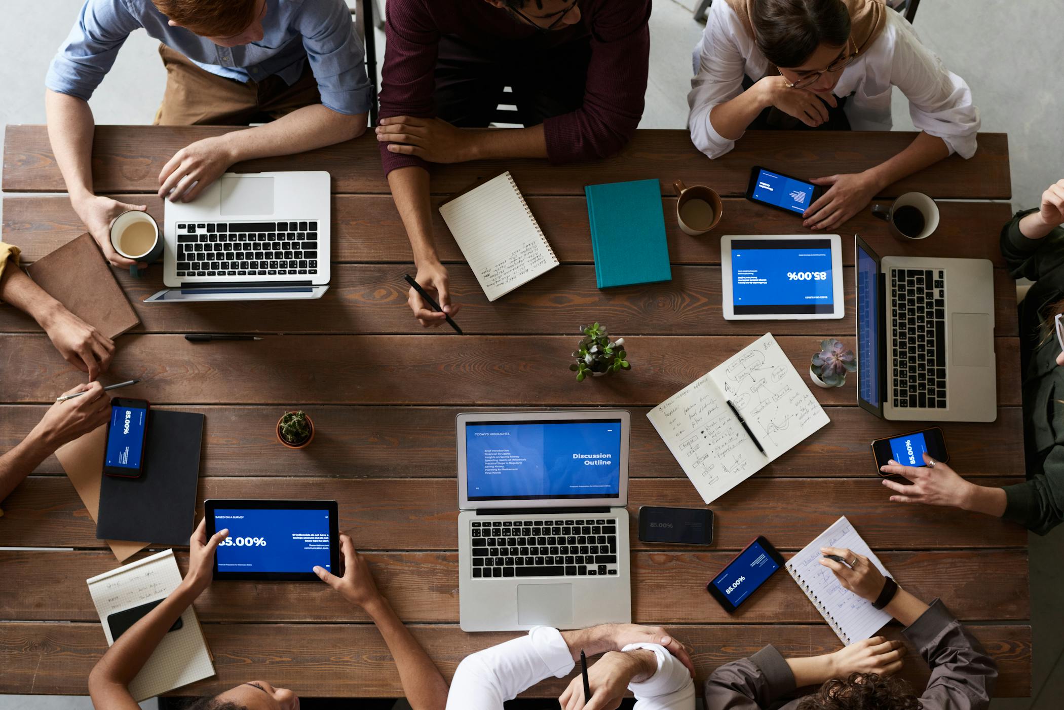 Overhead view of a diverse team in a business meeting using laptops and tablets showcasing North Carolina being good for businesses but not for workers.