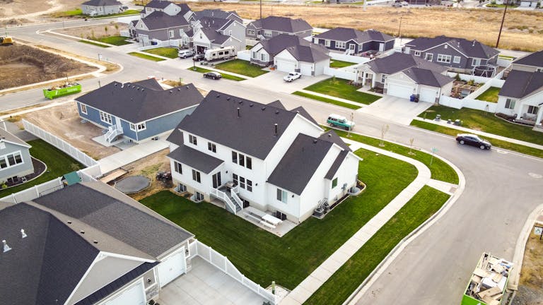 Scenic aerial view of a residential area featuring modern houses and green lawns showcasing the increase in HOA fees in neighborhoods.
