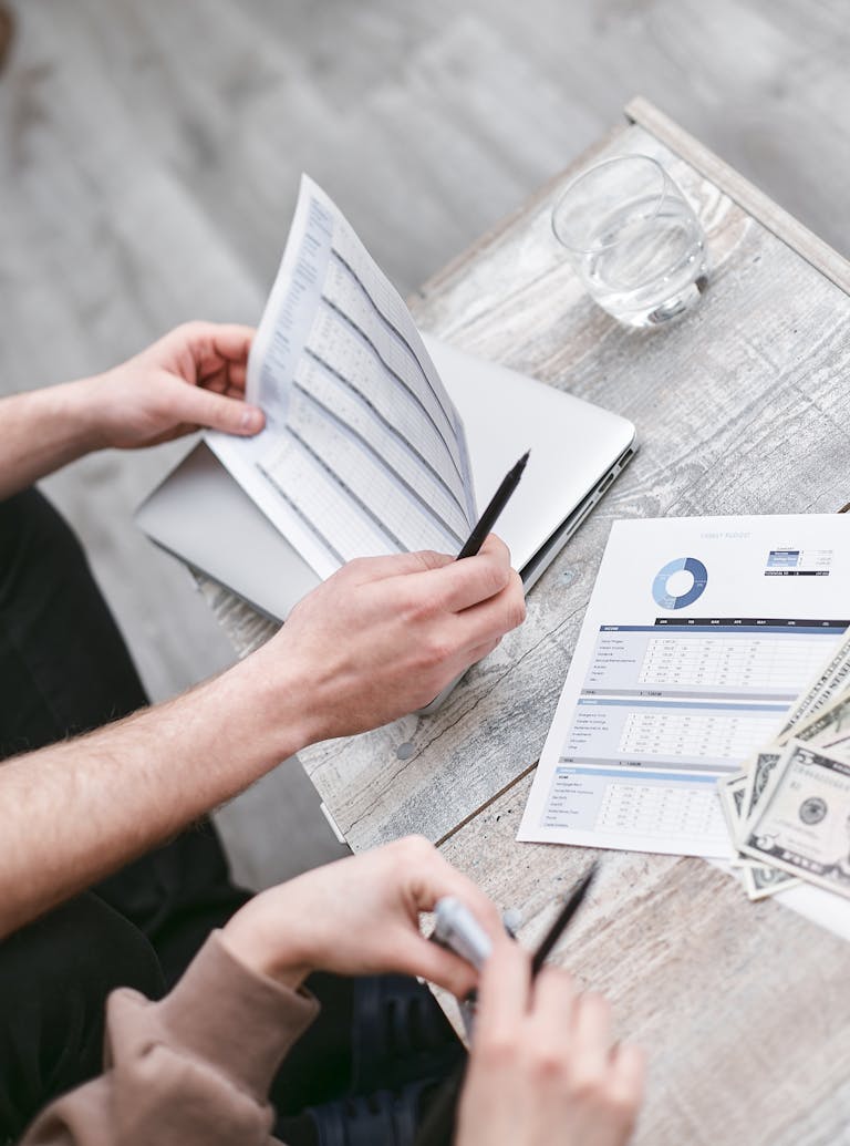 Two professionals reviewing financial documents with charts showing the true cost of vacancy for rental investments.