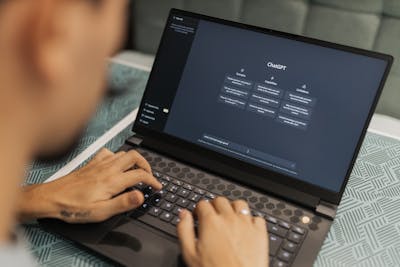 Close-up of a person typing on a laptop displaying the ChatGPT interface, symbolizing the ChatGPT integration with Zillow.