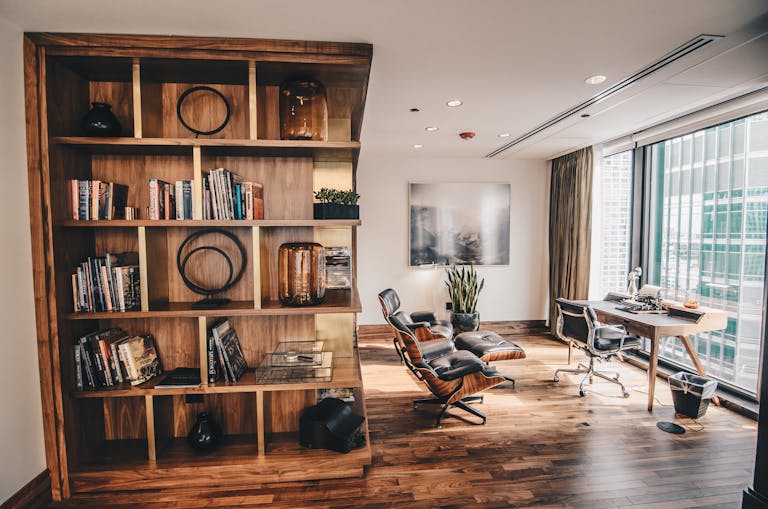 Stylish detached office space featuring a wooden bookshelf and a minimalist desk setup, ideal for remote workers.