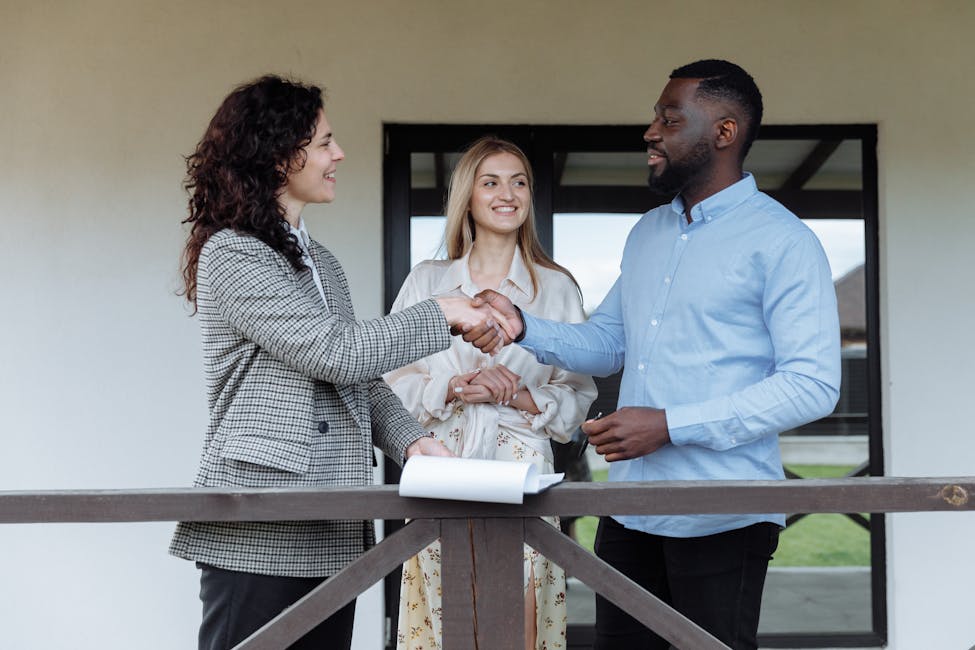 Three adults sealing a real estate deal with a handshake on a porch with the intention of making this a rental investment property.