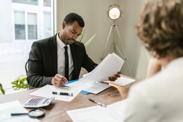 Professional businessman reviewing documents at a desk in a modern office setting showcasing a property owner taking their property off the market.