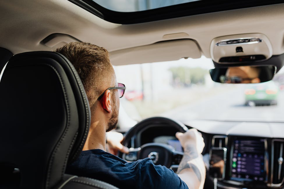 Rear view of a man driving a car with focus on interior details and steering showcasing driving on the new I-485 express lanes in Charlotte, North Carolina.