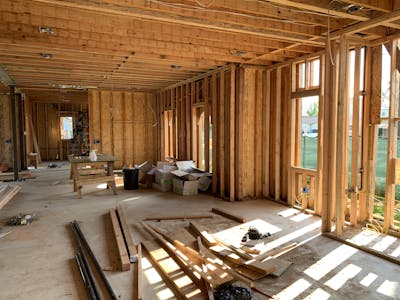 Sunlit interior with wood framing, showcasing build to rent construction progress and current market trends for investors.