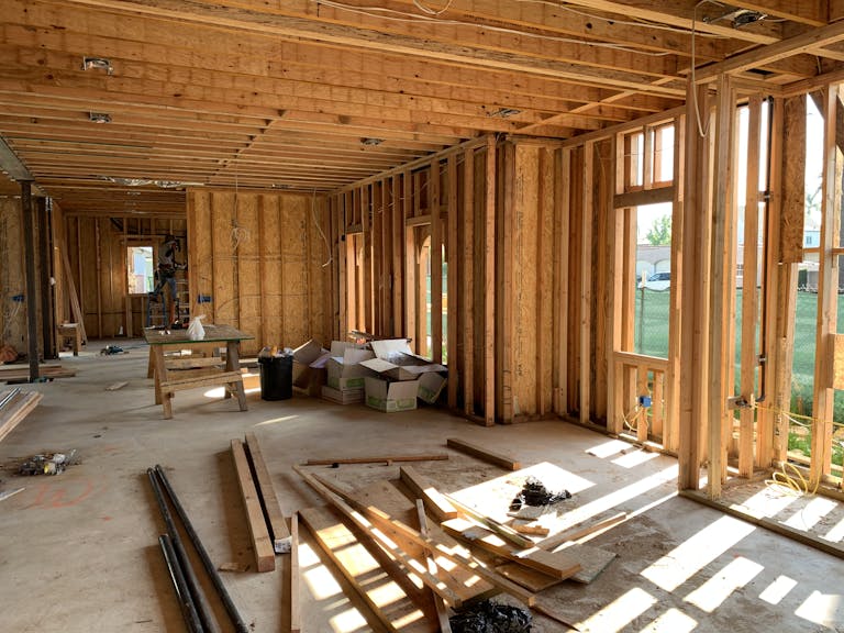 Sunlit interior with wood framing, showcasing build to rent construction progress and current market trends for investors.