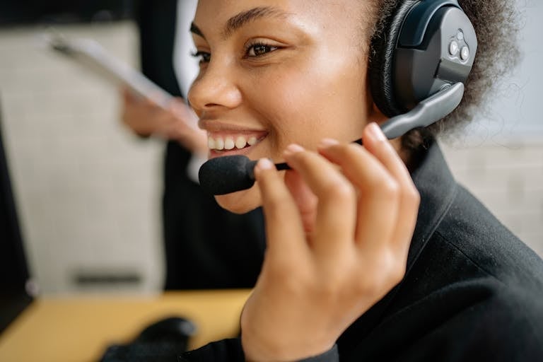 Portrait of a smiling call center agent wearing a headset in an office setting symbolizing a team member from MoveZen who will answer the phone for whoever calls.