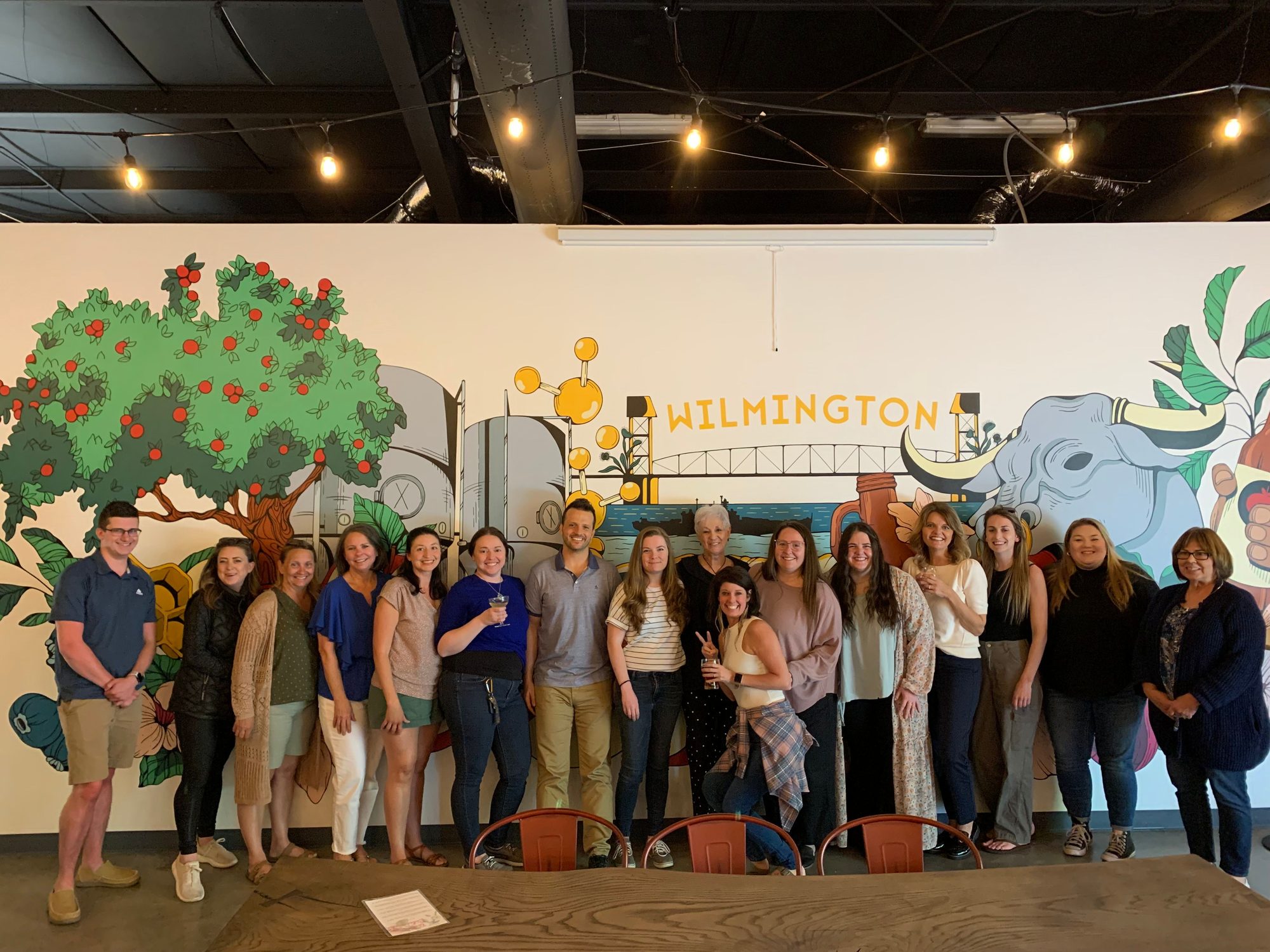 MoveZen Property Management team group photo in front of a Wilmington mural